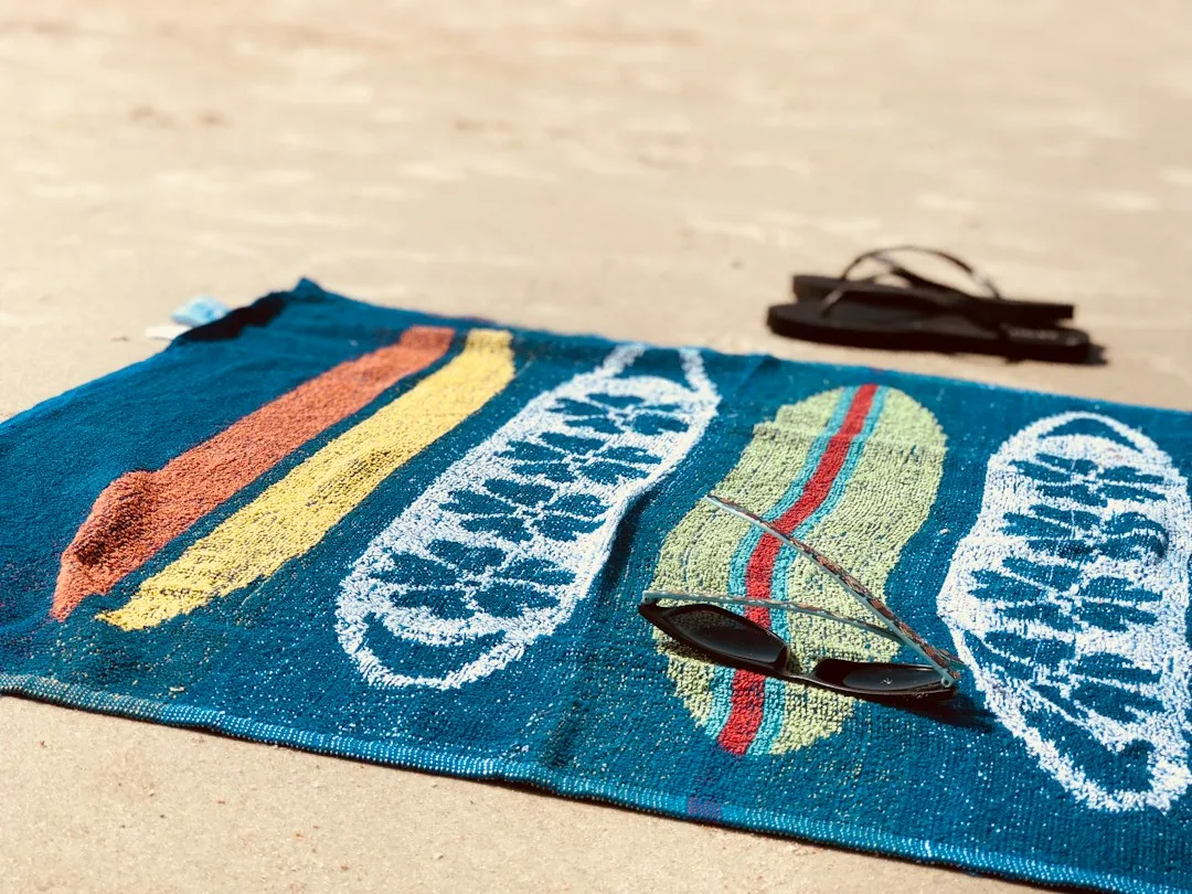 A rolled quick-dry towel in a faded teal stripe
